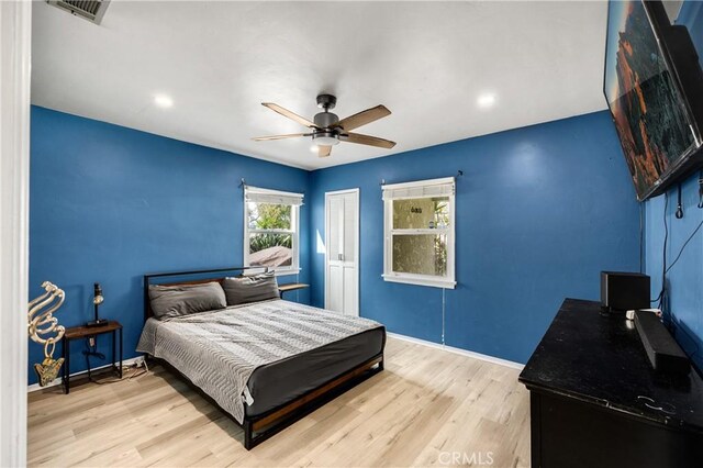 bedroom featuring ceiling fan, visible vents, baseboards, a closet, and light wood finished floors