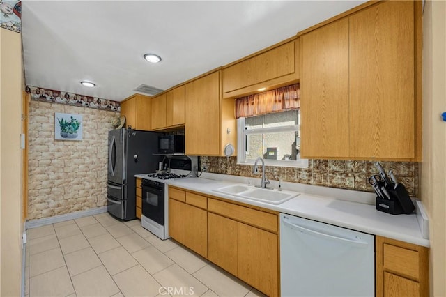 kitchen featuring black microwave, a sink, range with gas stovetop, light countertops, and dishwasher