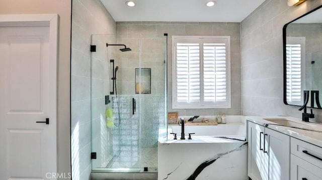 bathroom featuring recessed lighting, a garden tub, a shower stall, and vanity