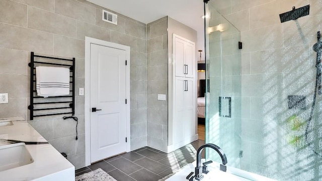 ensuite bathroom featuring a stall shower, a garden tub, tile walls, and tile patterned floors