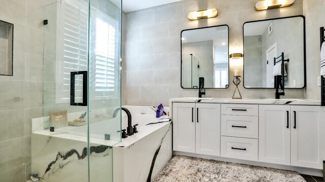 full bath featuring a stall shower, plenty of natural light, tile walls, and a bath