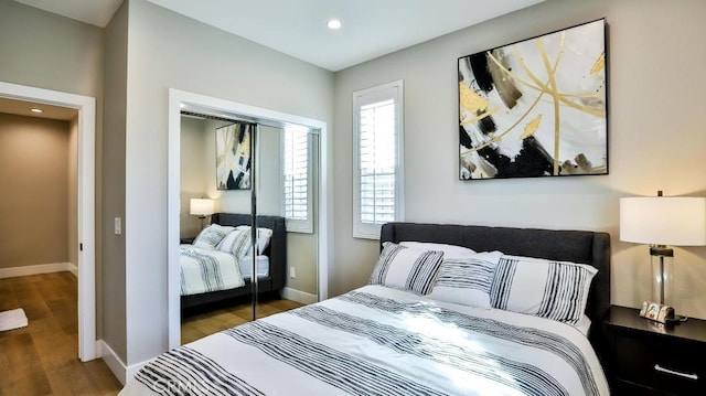 bedroom featuring a closet, baseboards, and wood finished floors