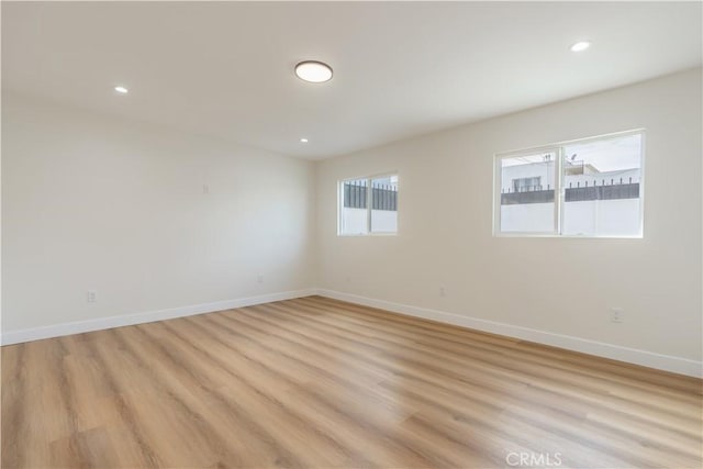 unfurnished room featuring light wood-style floors, recessed lighting, and baseboards