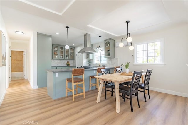 dining area featuring light wood finished floors, recessed lighting, and baseboards