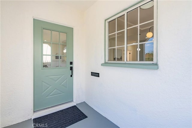 property entrance with stucco siding