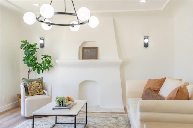 living room featuring light wood-type flooring, baseboards, a notable chandelier, and recessed lighting