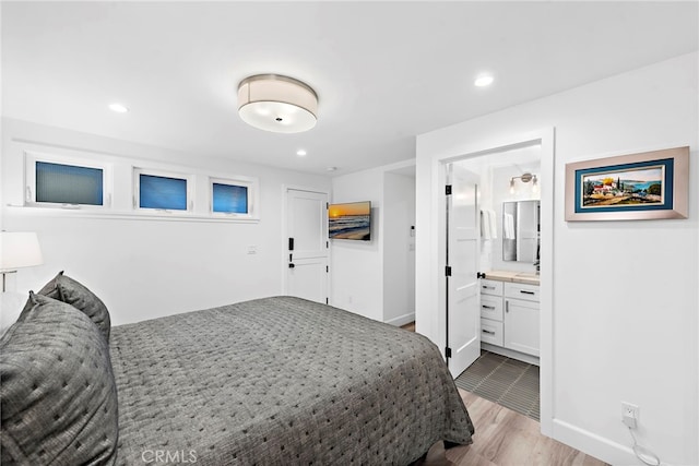 bedroom featuring recessed lighting, baseboards, light wood-style flooring, and ensuite bath