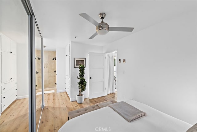 bedroom with light wood-style floors, ceiling fan, baseboards, and ensuite bathroom