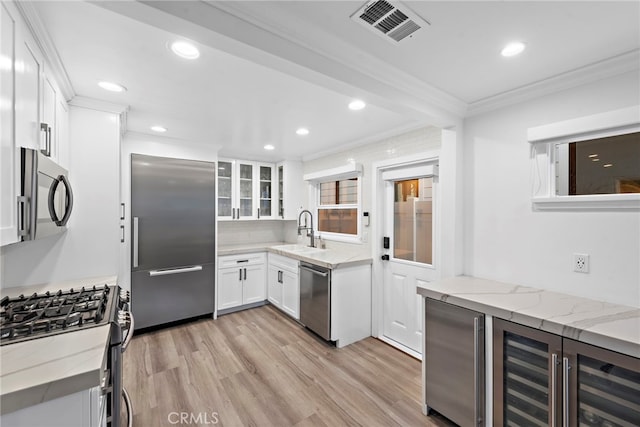 kitchen featuring visible vents, appliances with stainless steel finishes, glass insert cabinets, white cabinetry, and light stone countertops