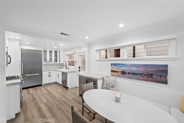 dining space featuring recessed lighting, light wood-style flooring, visible vents, and ornamental molding