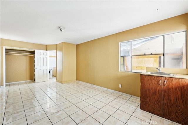 interior space featuring a sink, a closet, and light tile patterned flooring