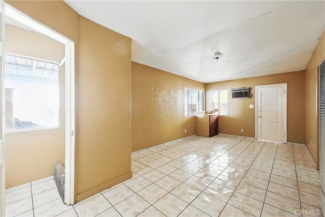 empty room featuring a wall mounted air conditioner and light tile patterned floors