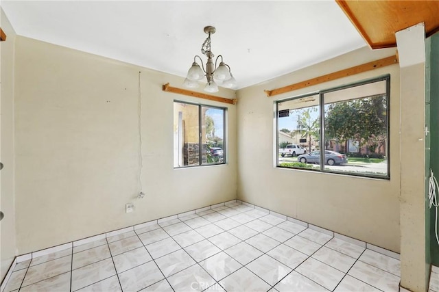 spare room with a notable chandelier