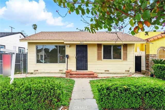 bungalow featuring a gate and fence