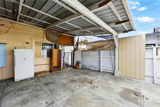 exterior space featuring freestanding refrigerator and electric panel