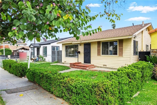 single story home featuring a front lawn, crawl space, and fence