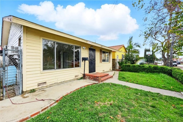 view of front of property featuring fence, a front lawn, and crawl space
