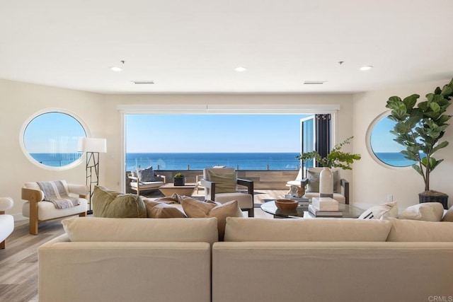 living room with a water view, light wood finished floors, visible vents, and recessed lighting