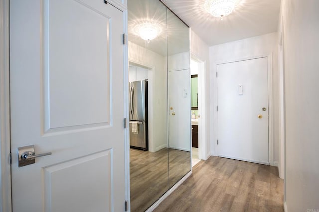 hall with light wood-type flooring and baseboards