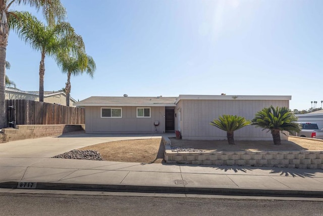 view of front of home with driveway and fence