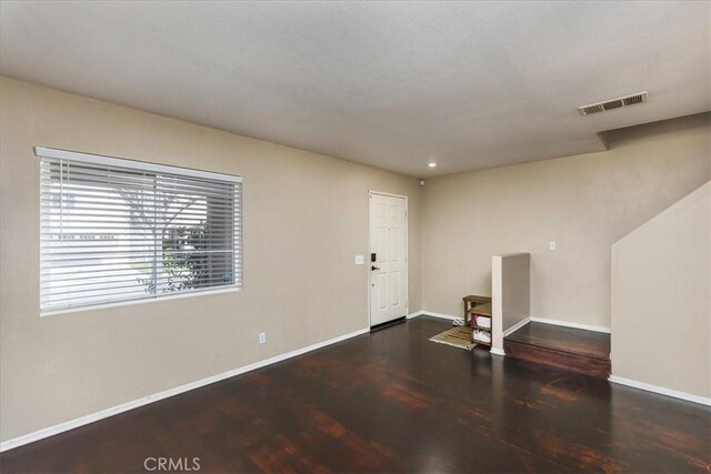 entrance foyer featuring dark wood-style flooring, visible vents, and baseboards