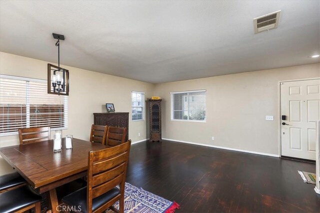 dining space with baseboards, visible vents, and dark wood finished floors