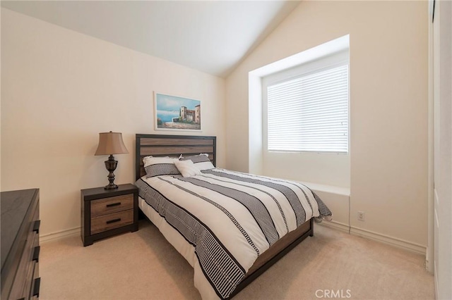 bedroom featuring lofted ceiling, baseboards, and light colored carpet