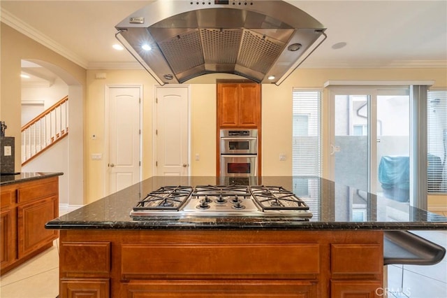 kitchen featuring appliances with stainless steel finishes, light tile patterned floors, dark stone countertops, and extractor fan