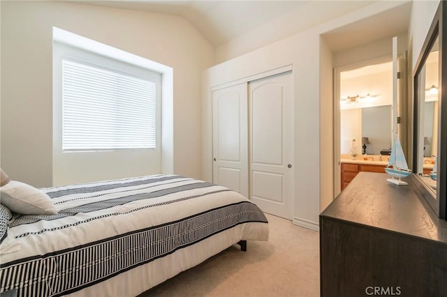 bedroom with light carpet, a closet, and lofted ceiling