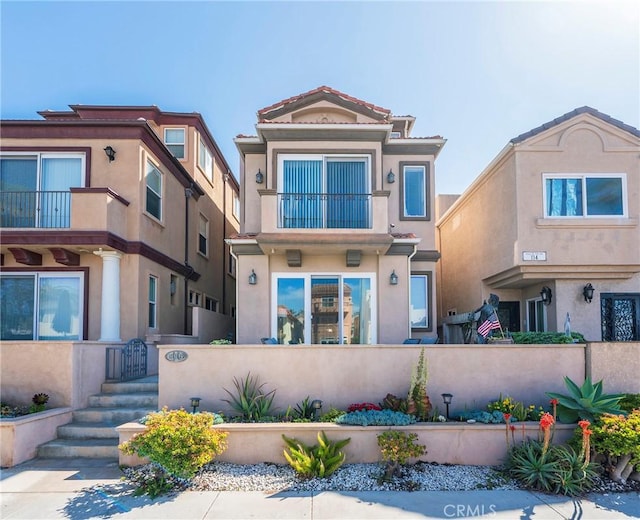 townhome / multi-family property with a fenced front yard and stucco siding