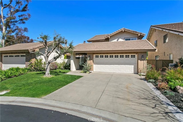 traditional-style house with an attached garage, fence, a tile roof, concrete driveway, and a front lawn