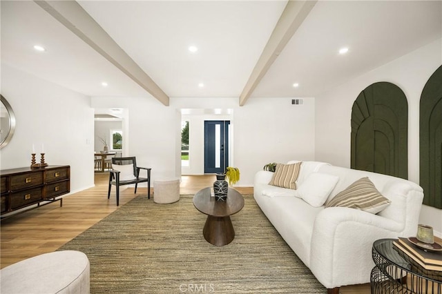 living room featuring light wood-style floors, visible vents, beam ceiling, and recessed lighting