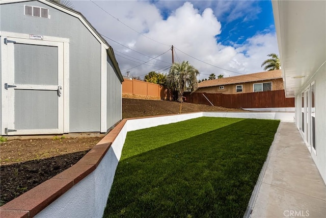 view of yard featuring an outbuilding, a storage unit, a fenced backyard, and visible vents