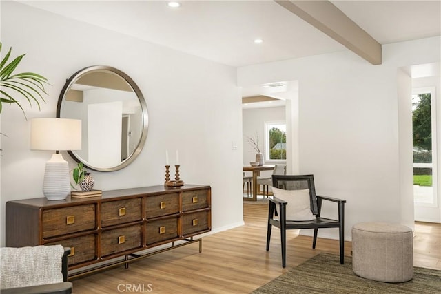 living area with light wood finished floors, baseboards, beam ceiling, and recessed lighting