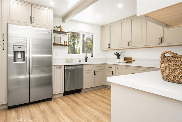 kitchen with open shelves, stainless steel appliances, light countertops, light wood-style floors, and a sink