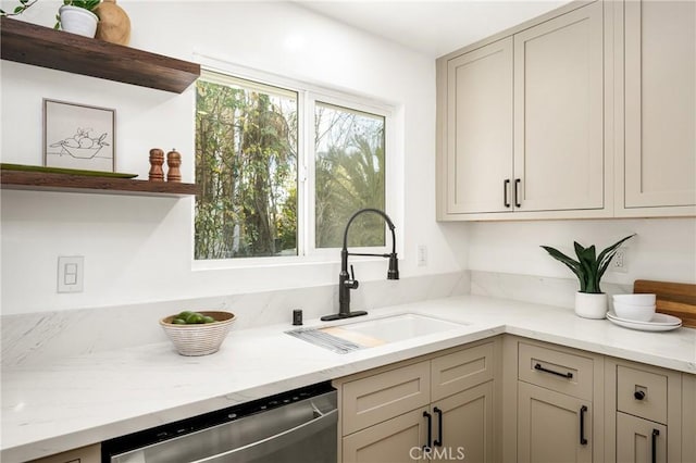 kitchen featuring light stone countertops, a sink, stainless steel dishwasher, and open shelves