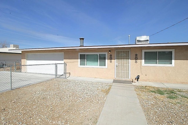 view of front facade featuring stucco siding, fence, a garage, cooling unit, and driveway