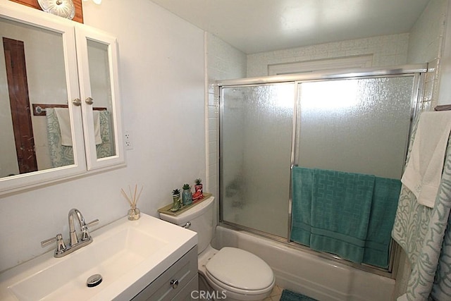 bathroom with shower / bath combination with glass door, vanity, and toilet