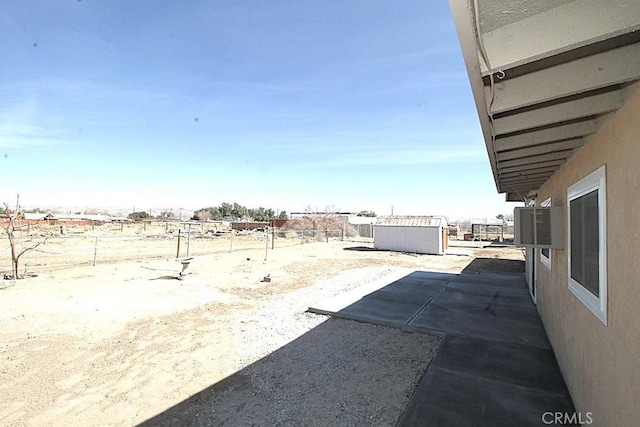 view of yard with a fenced backyard, a storage unit, and an outdoor structure