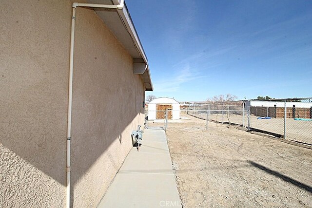 view of side of property with fence and stucco siding