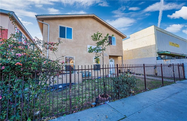 exterior space featuring a fenced front yard and stucco siding