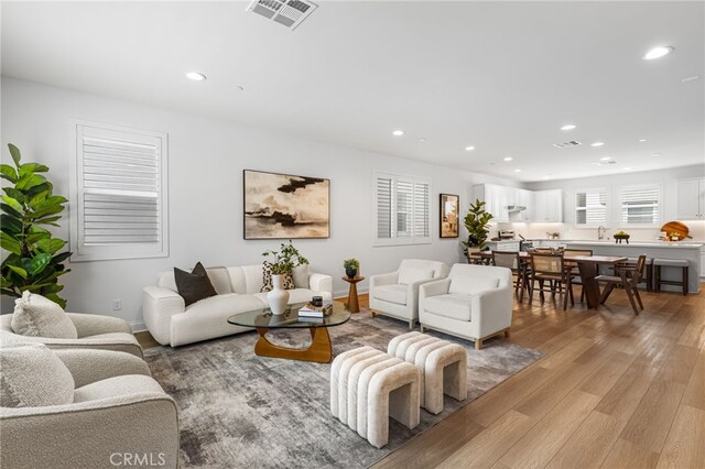 living room featuring recessed lighting, visible vents, and light wood-style floors