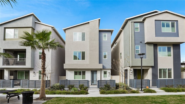 view of front of property with fence and stucco siding