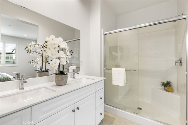 full bathroom with a stall shower, a sink, and double vanity