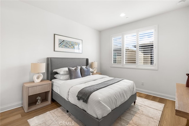 bedroom with light wood finished floors, baseboards, and recessed lighting