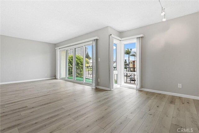 3695 Linden Ave Unit 11A, Long Beach, CA 90807 - empty room with rail lighting, light wood finished floors, and baseboards