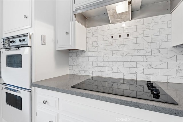 3695 Linden Ave Unit 11A, Long Beach, CA 90807 - kitchen featuring black electric cooktop, white double oven, wall chimney exhaust hood, decorative backsplash, and white cabinetry