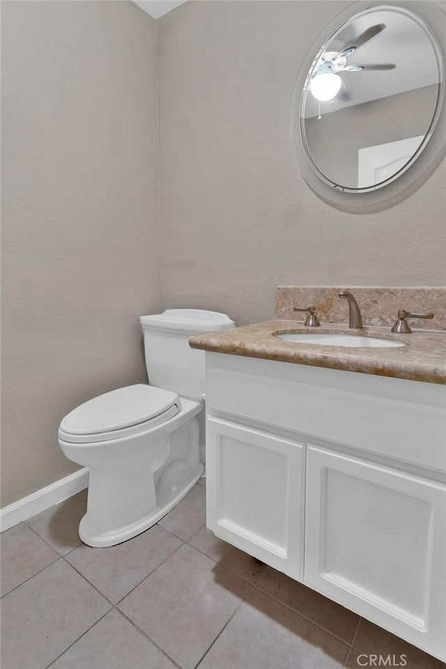 half bath featuring toilet, tile patterned flooring, a ceiling fan, and vanity