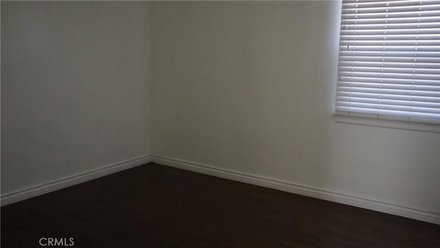 unfurnished room with baseboards