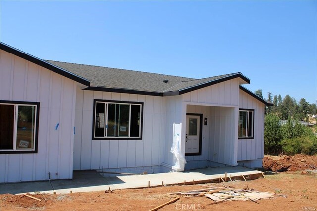 view of front of home with a shingled roof and board and batten siding